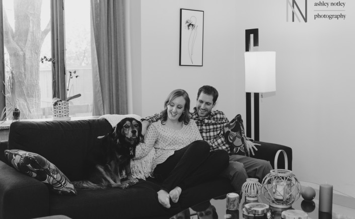 couple cuddled on the couch at home with dog