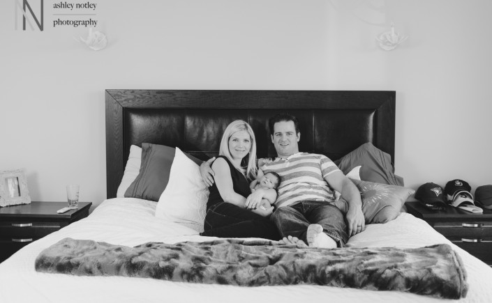 parents cuddling on the bed with baby girl at home