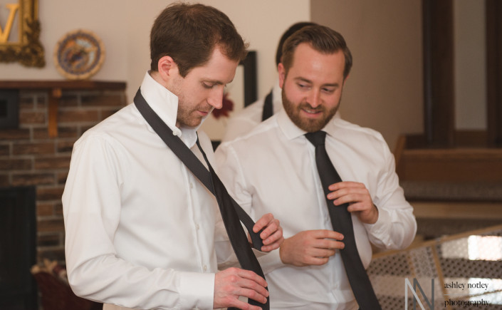 Groom and groomsmen putting on their ties