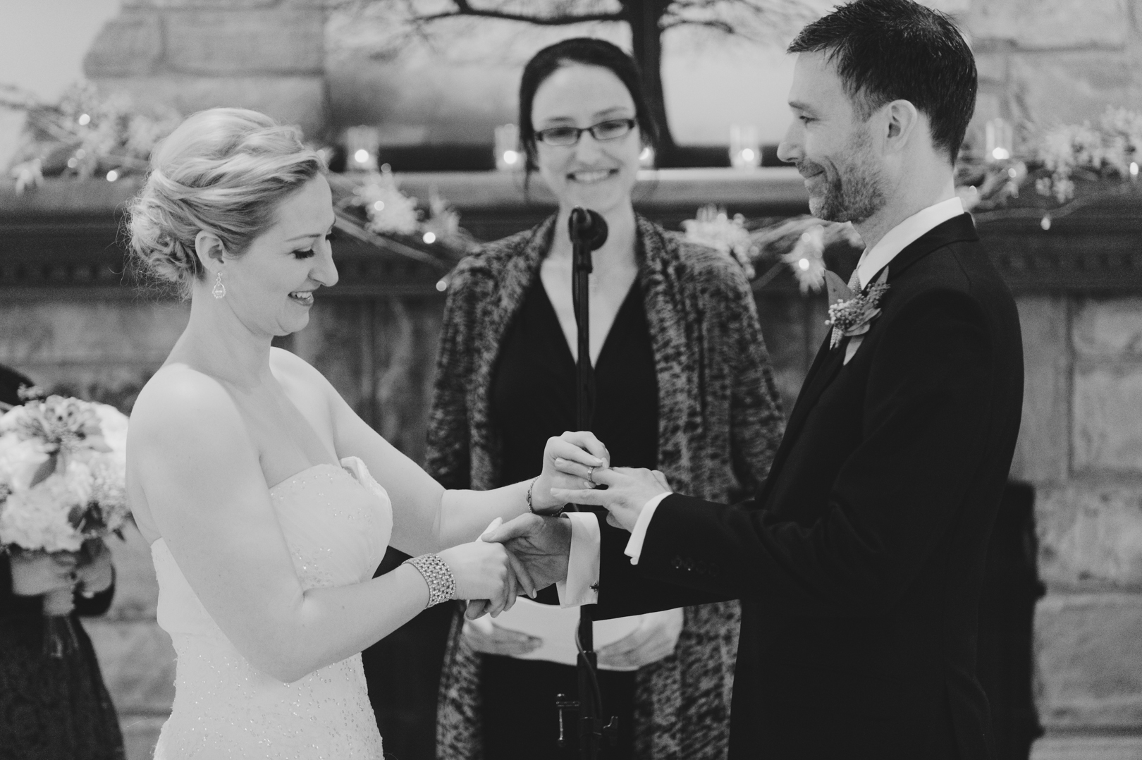 Bride putting on groom's ring at wedding ceremony