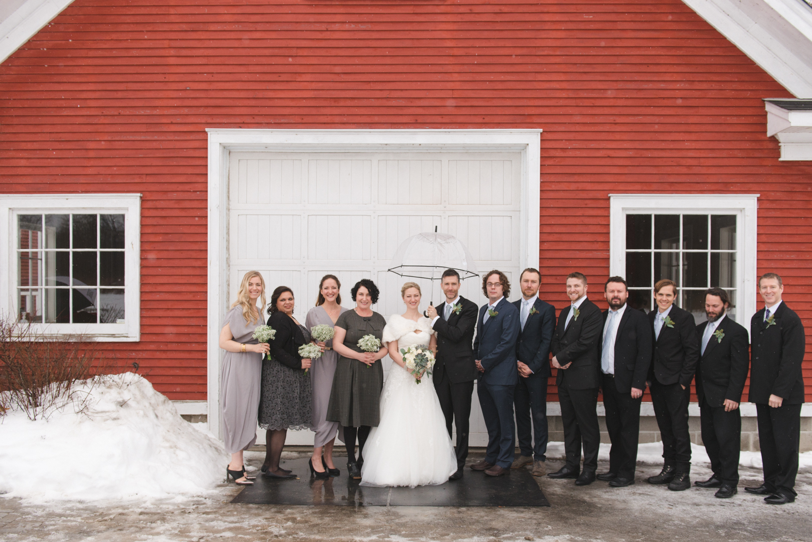 Wedding party in front of white door at winter wedding at Temples Sugar Bush