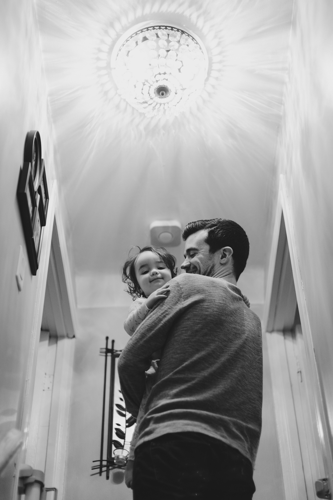 Little girl and dad going upstairs to get dressed on a Saturday morning. Photo by Ashley Notley Photography.