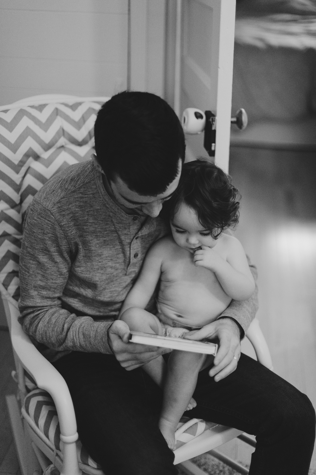 Dad and daughter reading a book together on Satruday morning. Photo by Ashley Notley Photography.