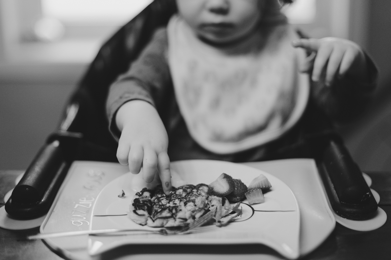 Little girl eating her pancakes with her hands. Dad and daughter playing together on Saturday morning. Photo by Ashley Notley Photography.
