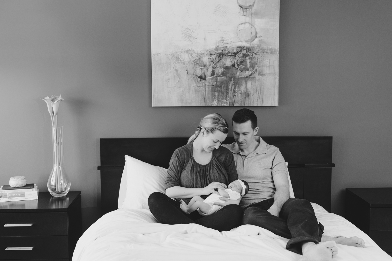 parents of baby girl cuddling on the bed