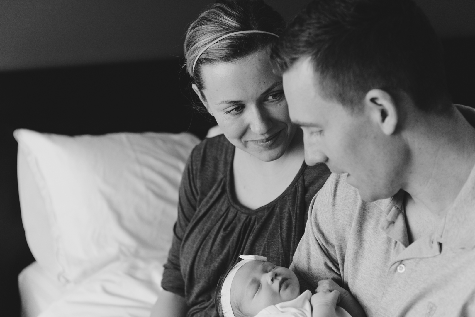 wife admiring her husband as he hold's their baby girl