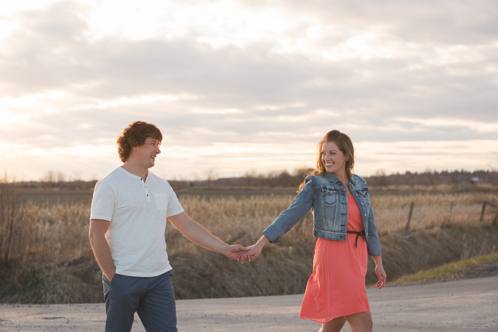 Engagement couple walking hand in hand in the sunset