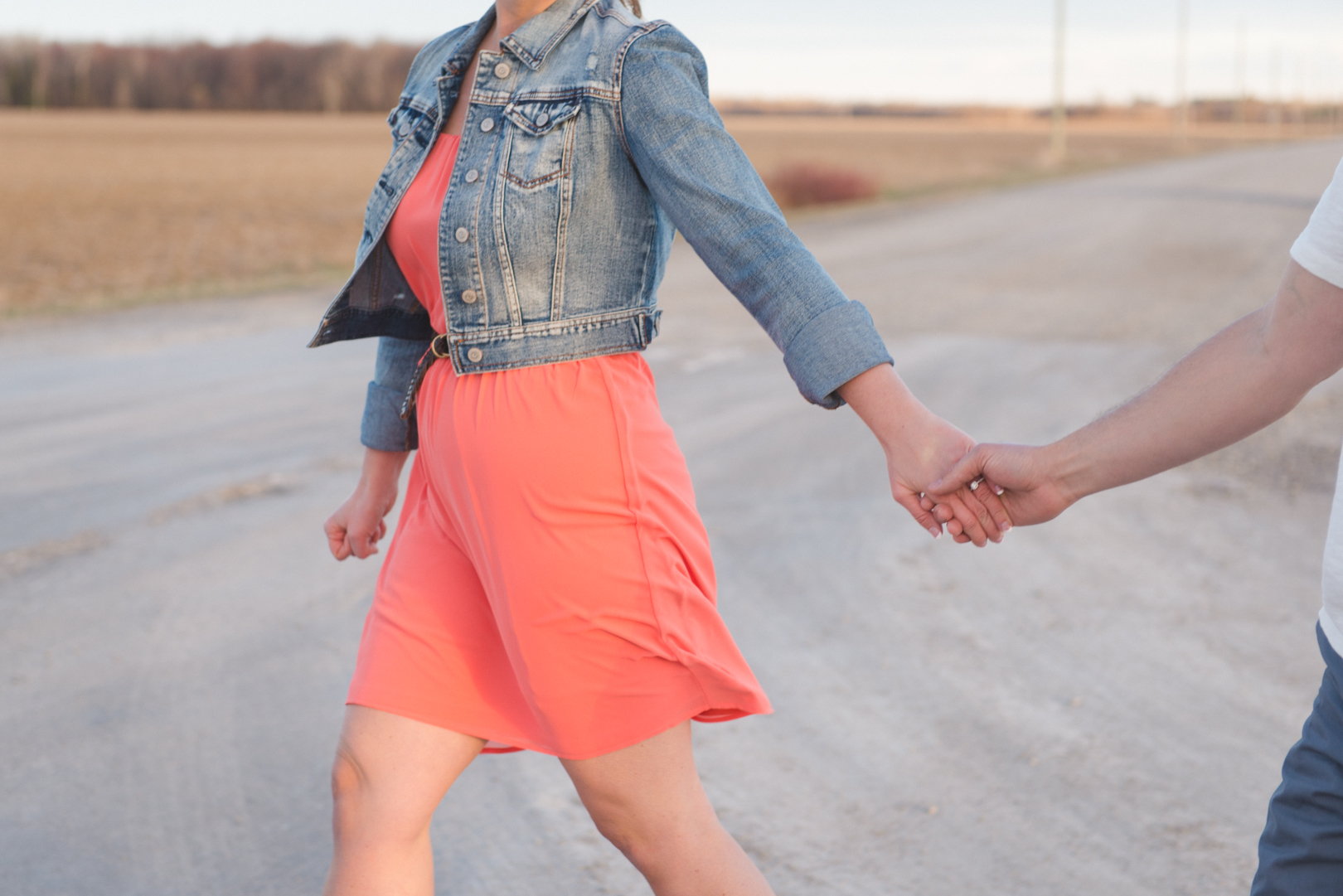 Engagement couple walking hand in hand in the sunset