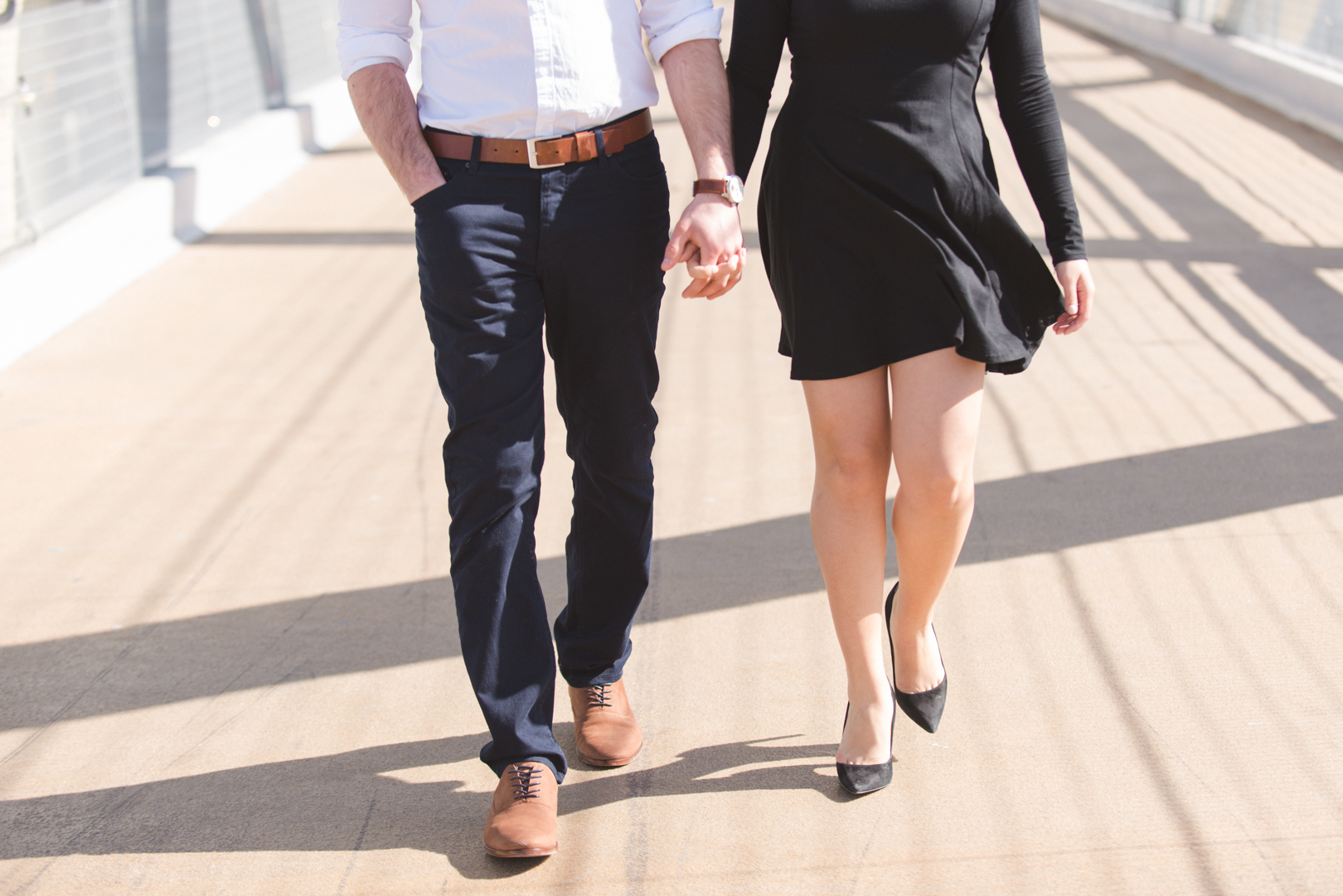 Couple walking hand in hand on bridge in Toronto