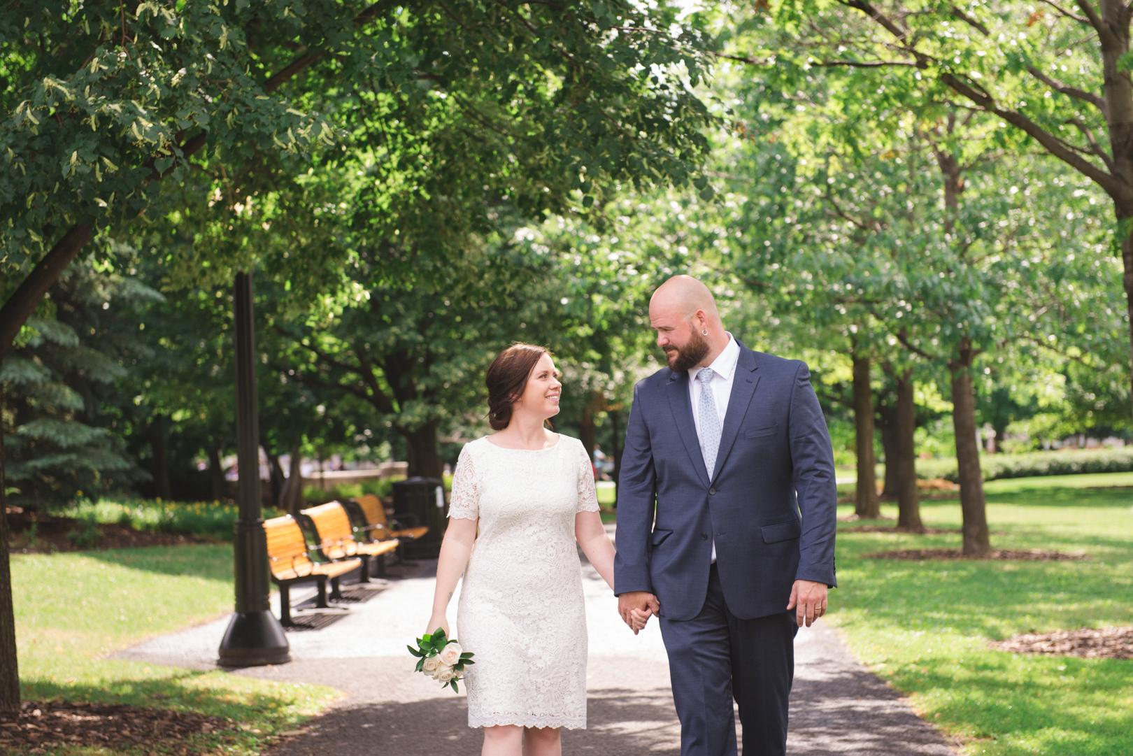 bride and groom walking through confederation park