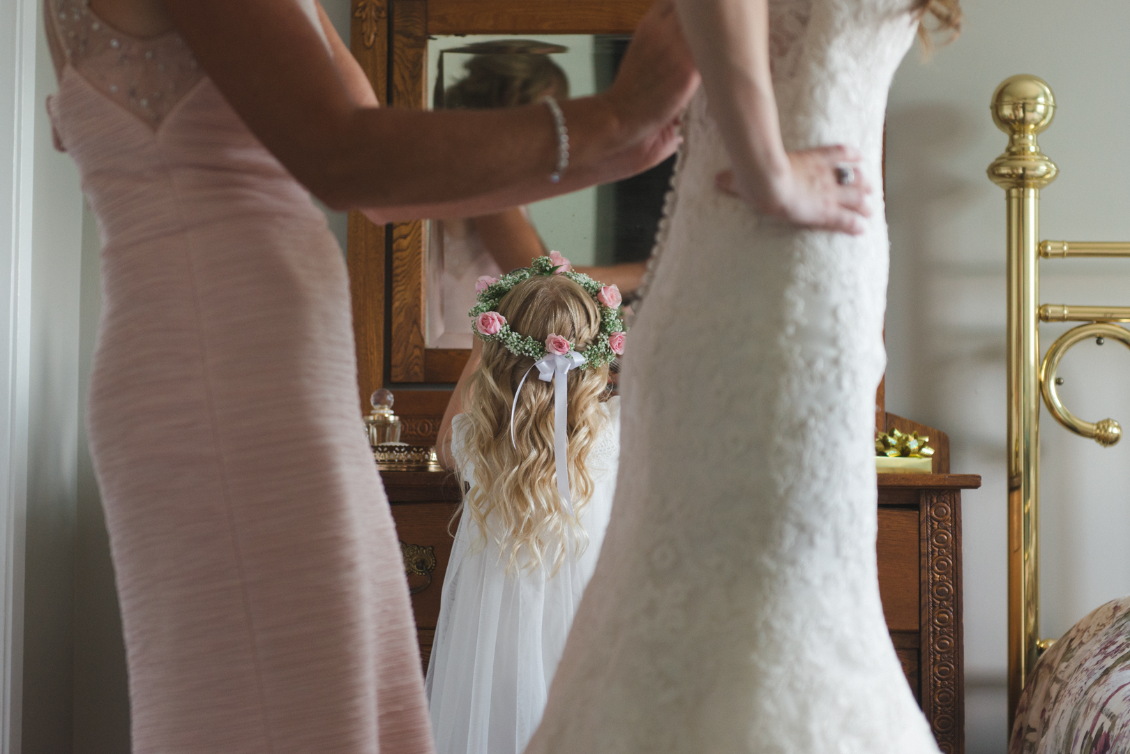 mother of the bride tying up bride's dress