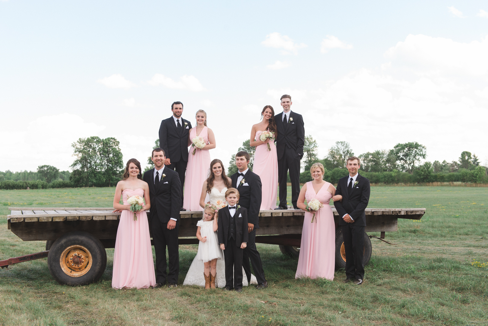 wedding party on hay wagon at family farm wedding