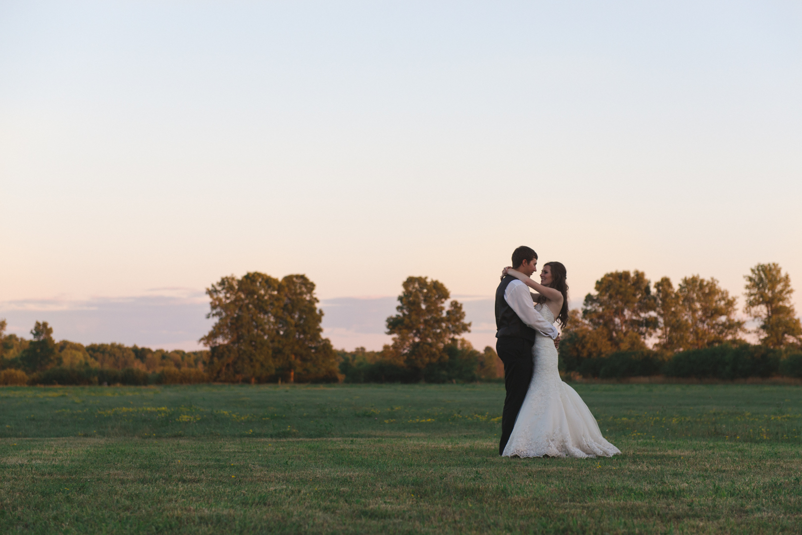bride and groom at sunset in fields