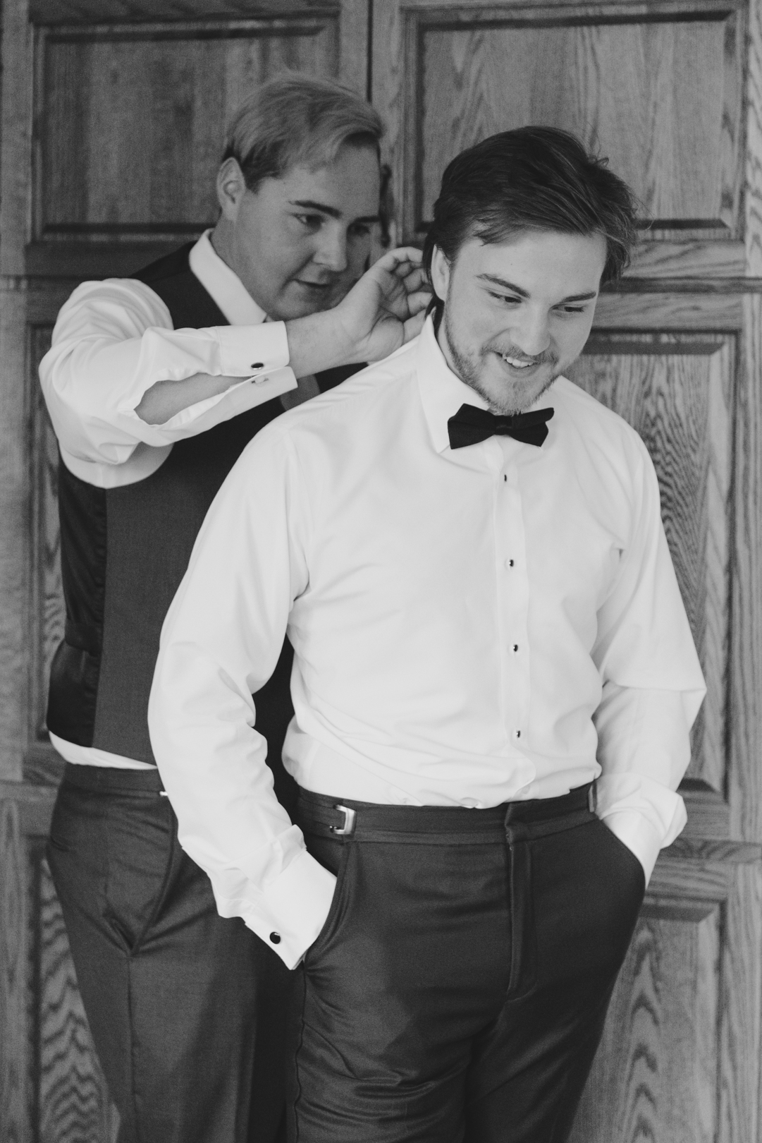groomsmen putting on groom's bowtie