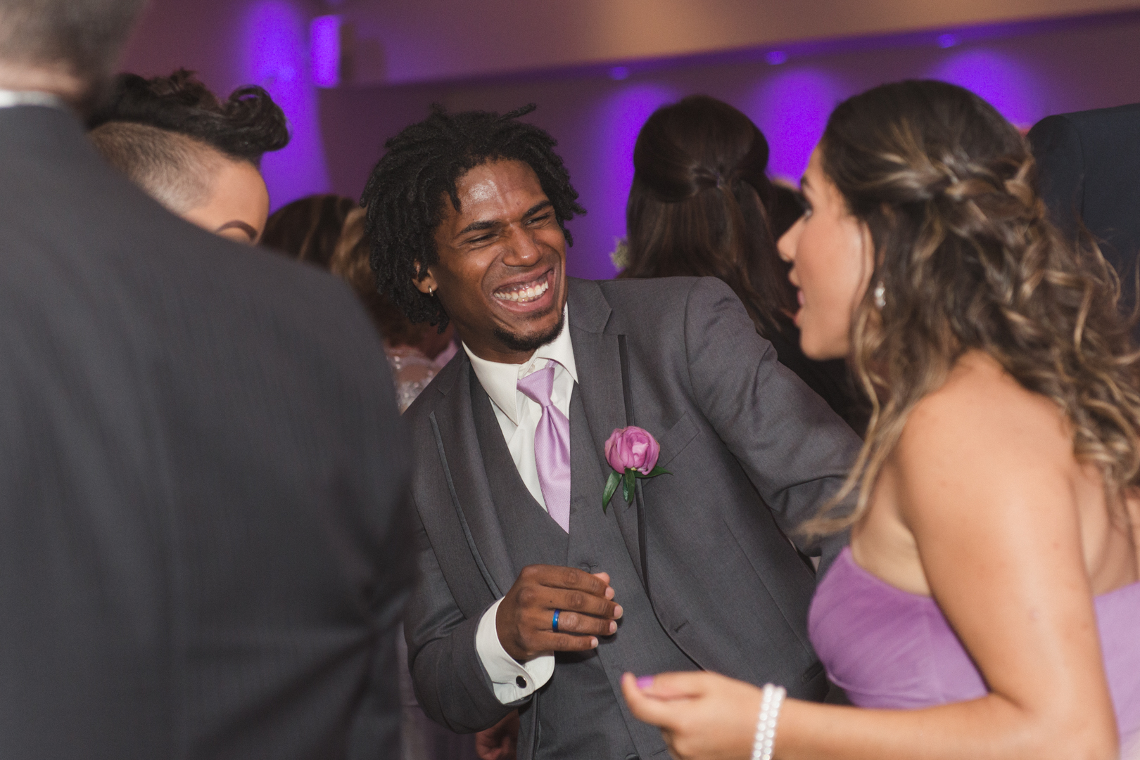 groomsman laughing with bridesmaid on dancefloor