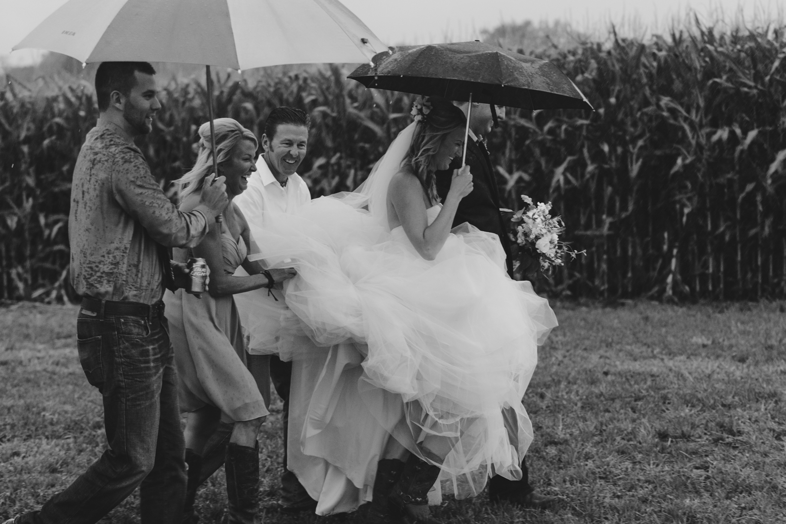 bride and her entourage walking with an umbrella