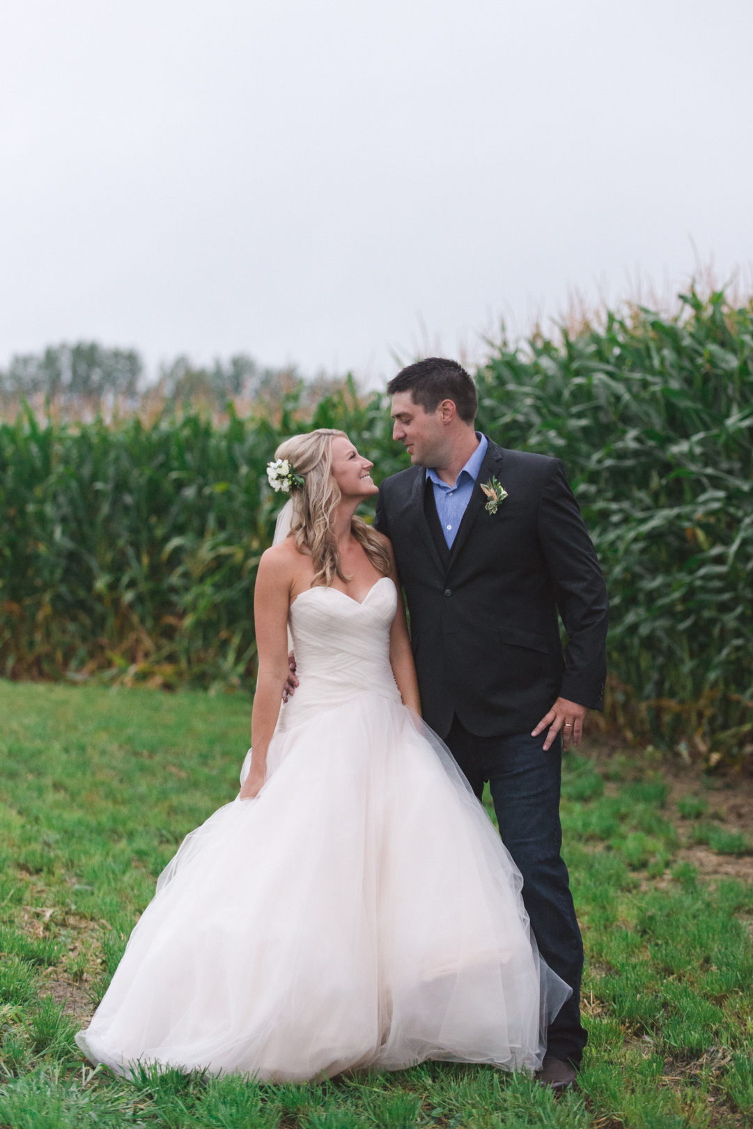 bride and groom in front of corn fields