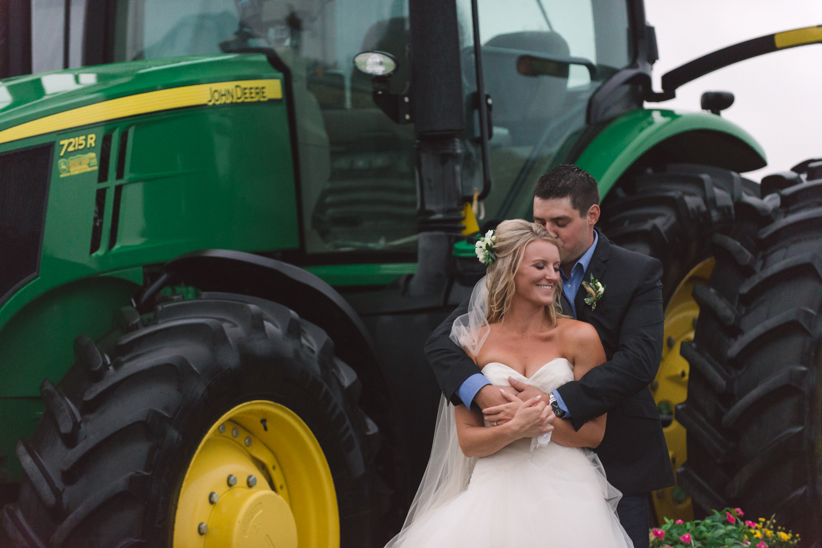 bride and groom in front of john deer tractor