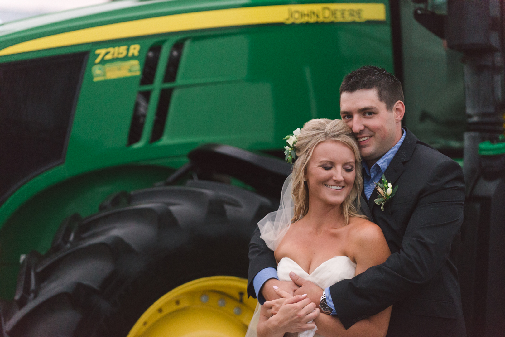 bride and groom in front of john deer tractor