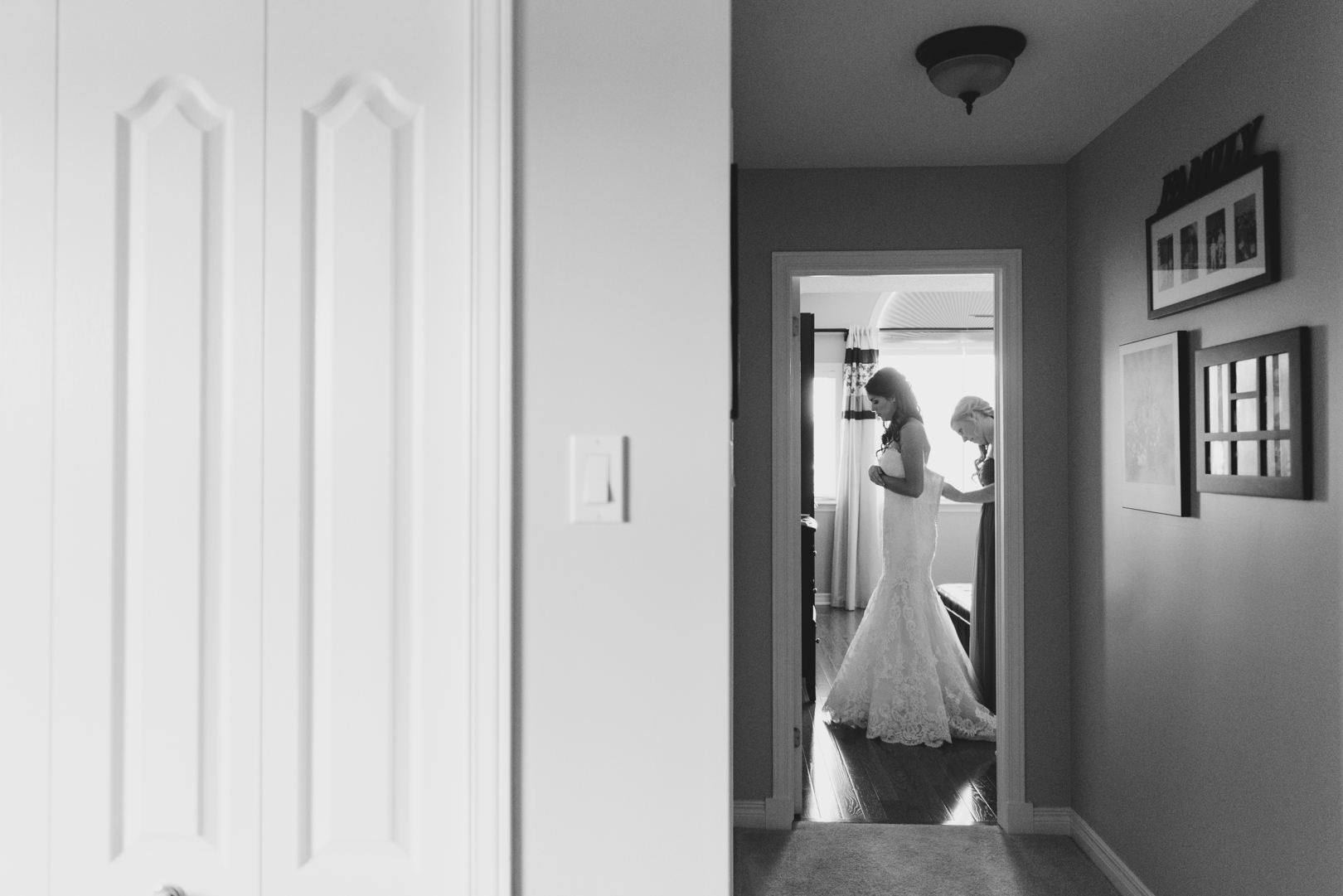 bride putting on her wedding dress down the hall
