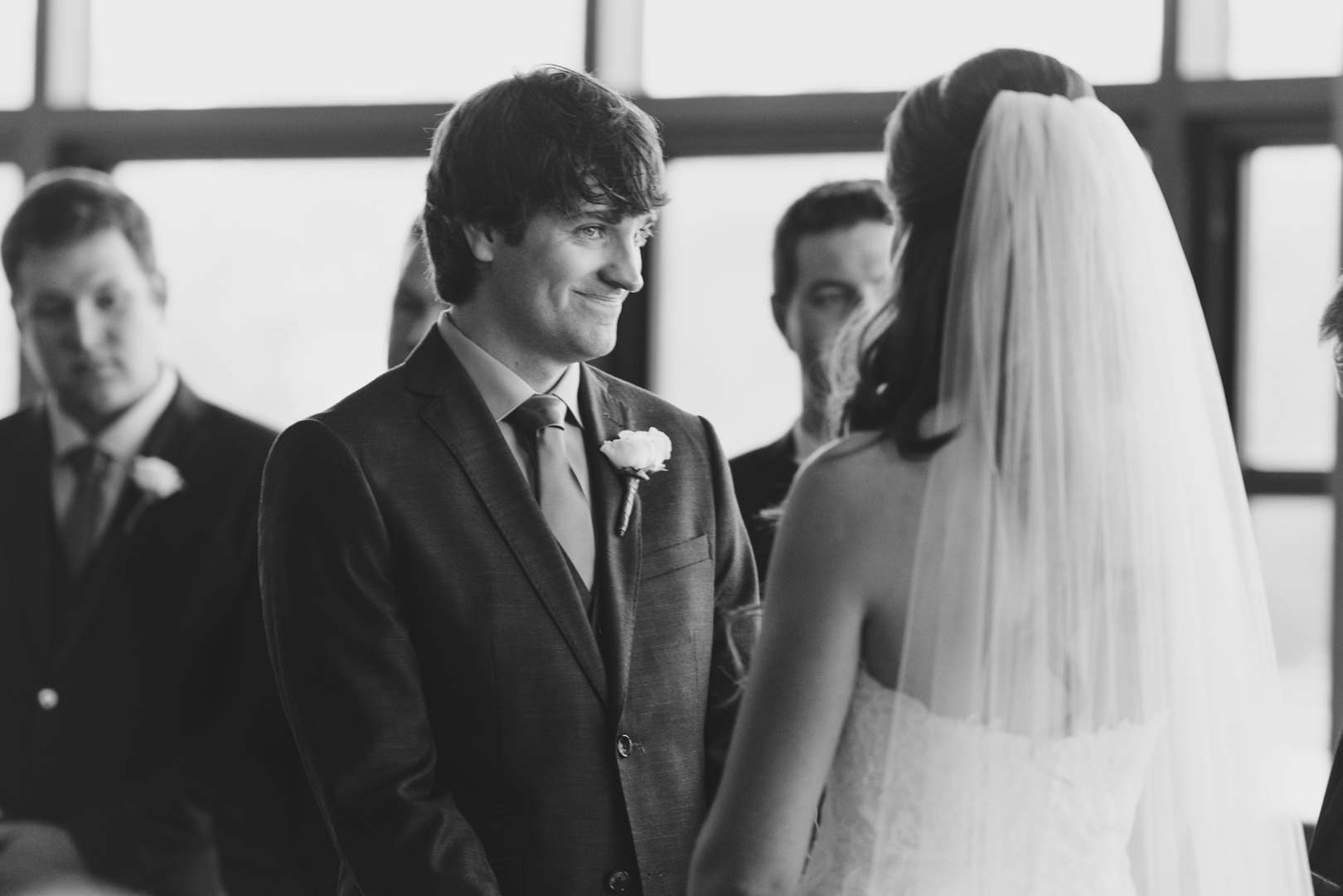 groom smiling at bride during the ceremony