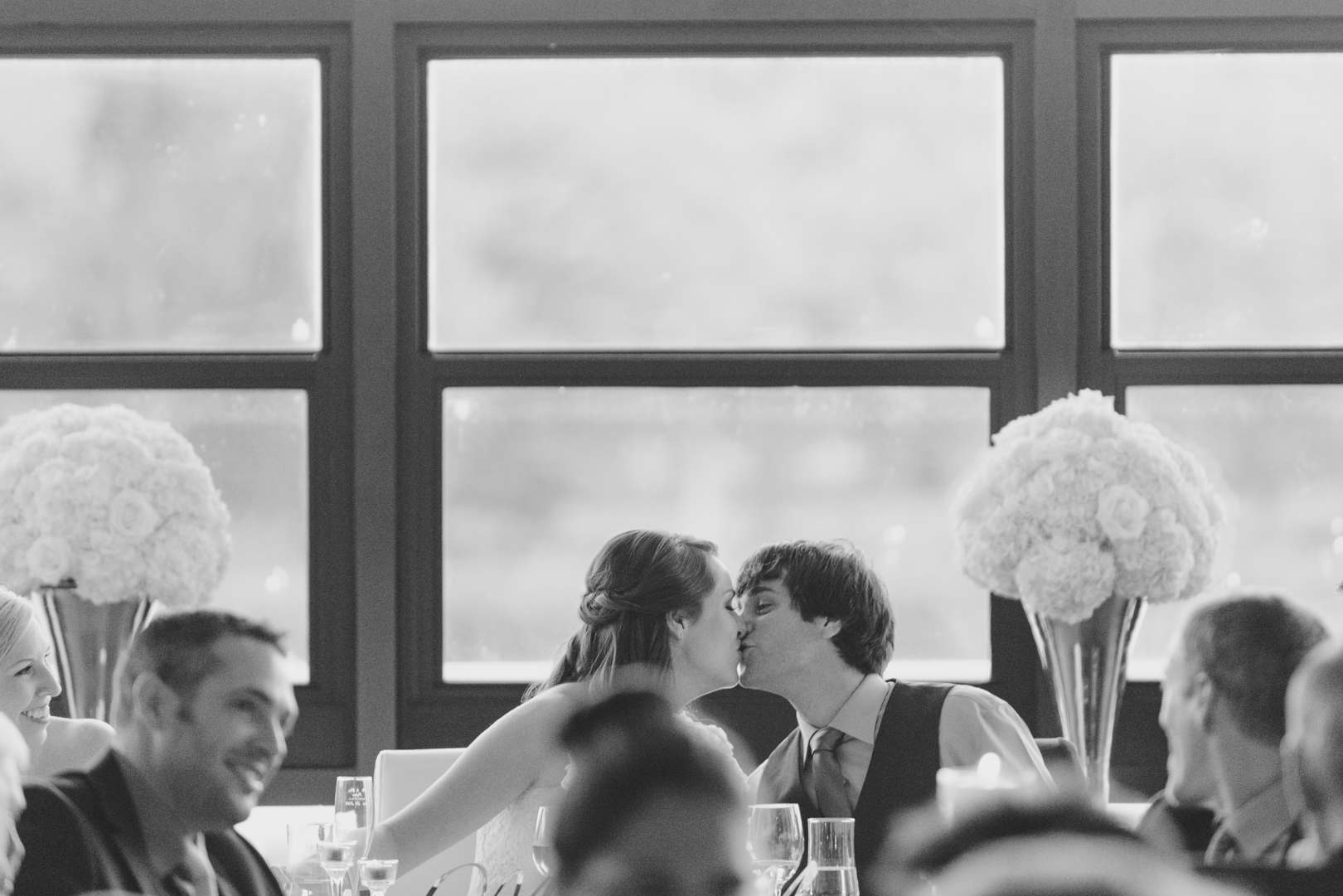 bride and groom kissing at the head table