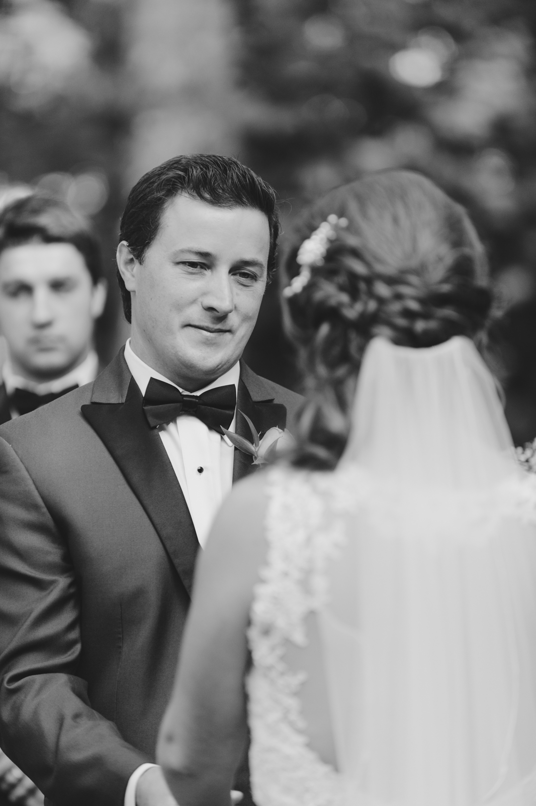 Groom smiling at his bride during the ceremony