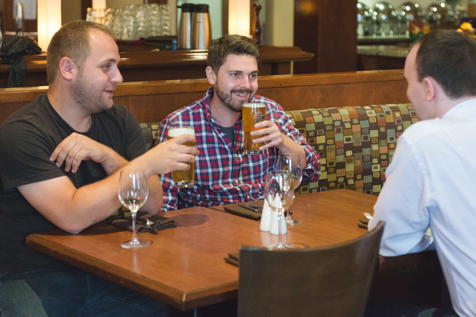 groom and groomsmen drinking beer at hotel bar