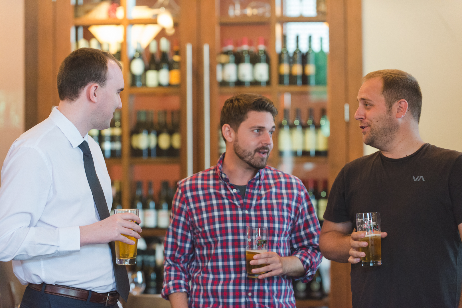 groom and groomsmen drinking beer at hotel bar