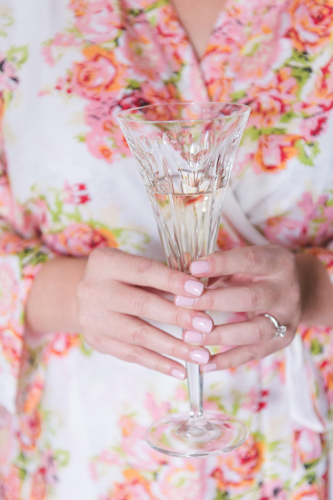 bride holding antique champagne glass in floral robe