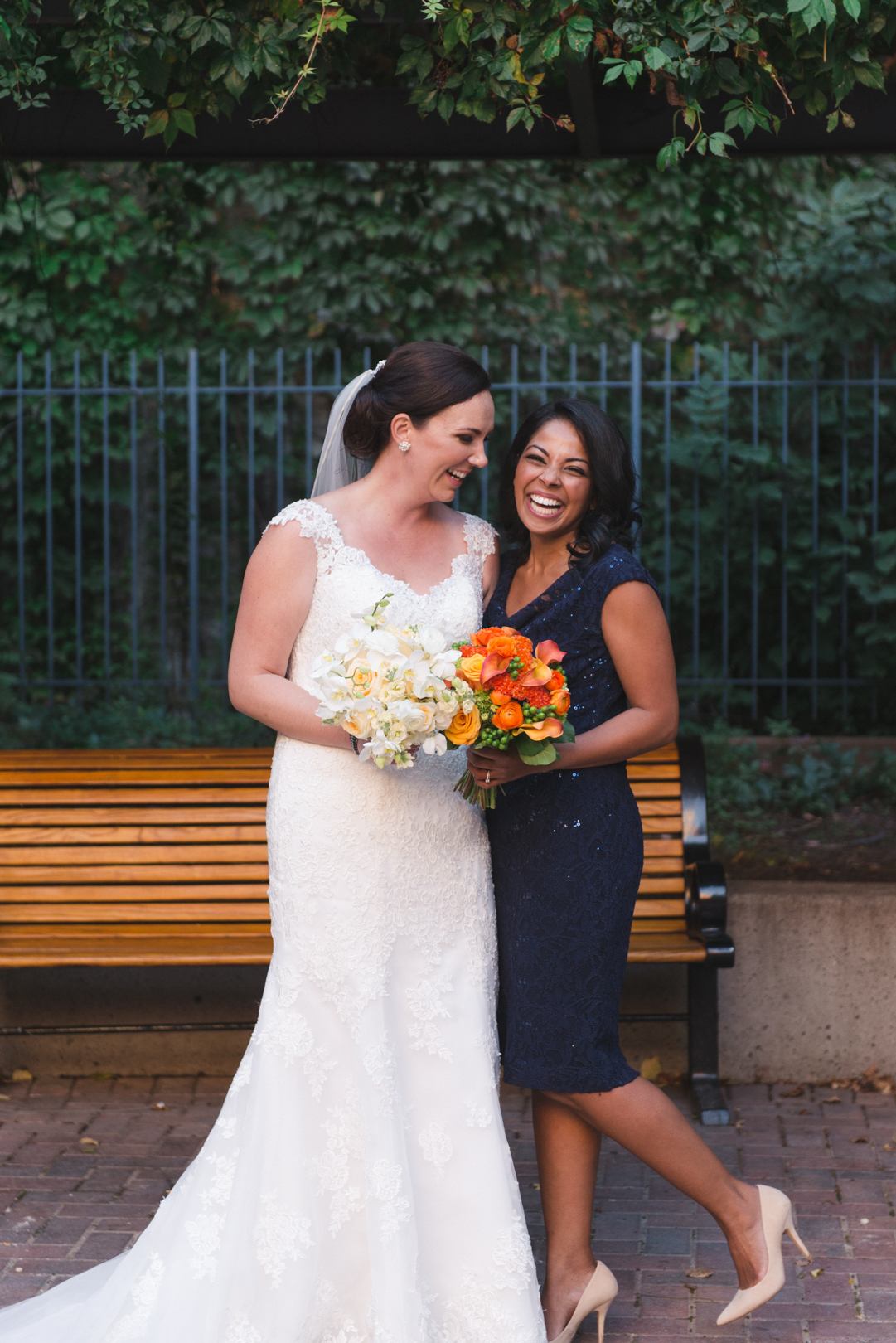 bride and bridesmaid laughing in courtyard in byward market