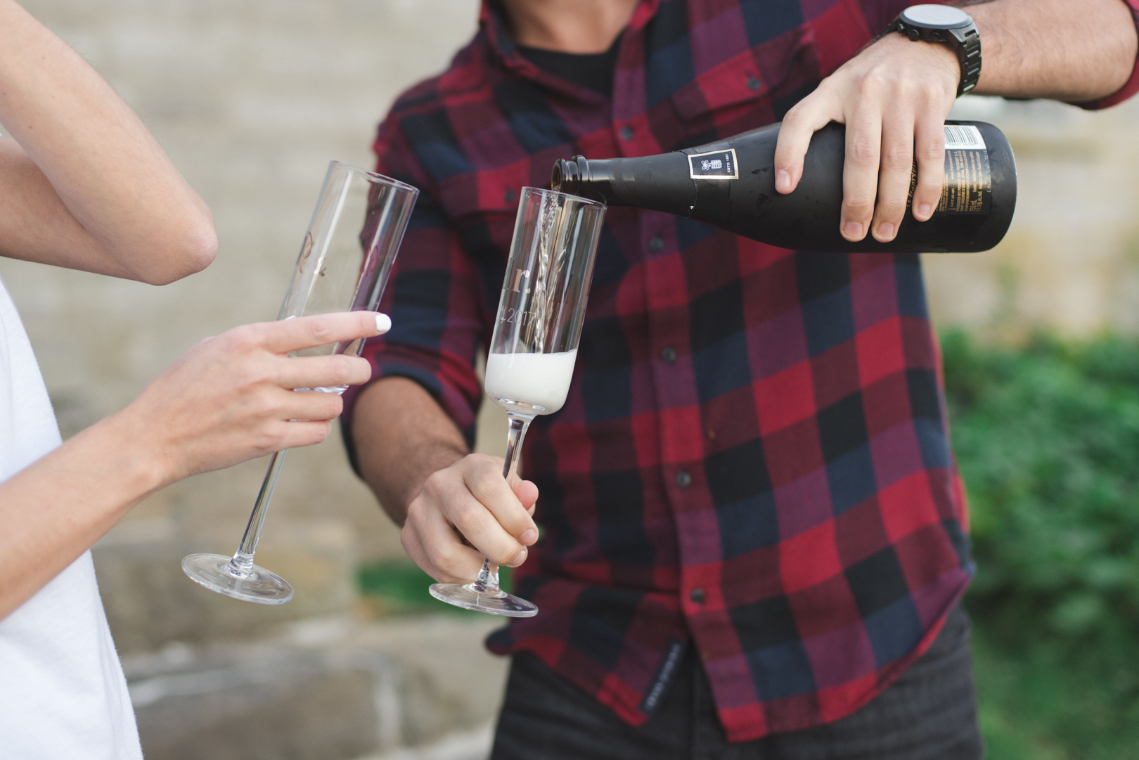 engaged couple pouring champagne into mr and mrs champagne flutes