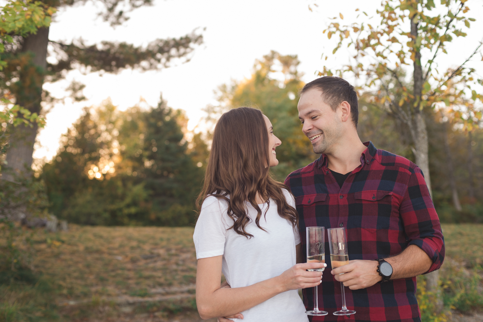 engaged couple at sunset enjoying a glass of champagne