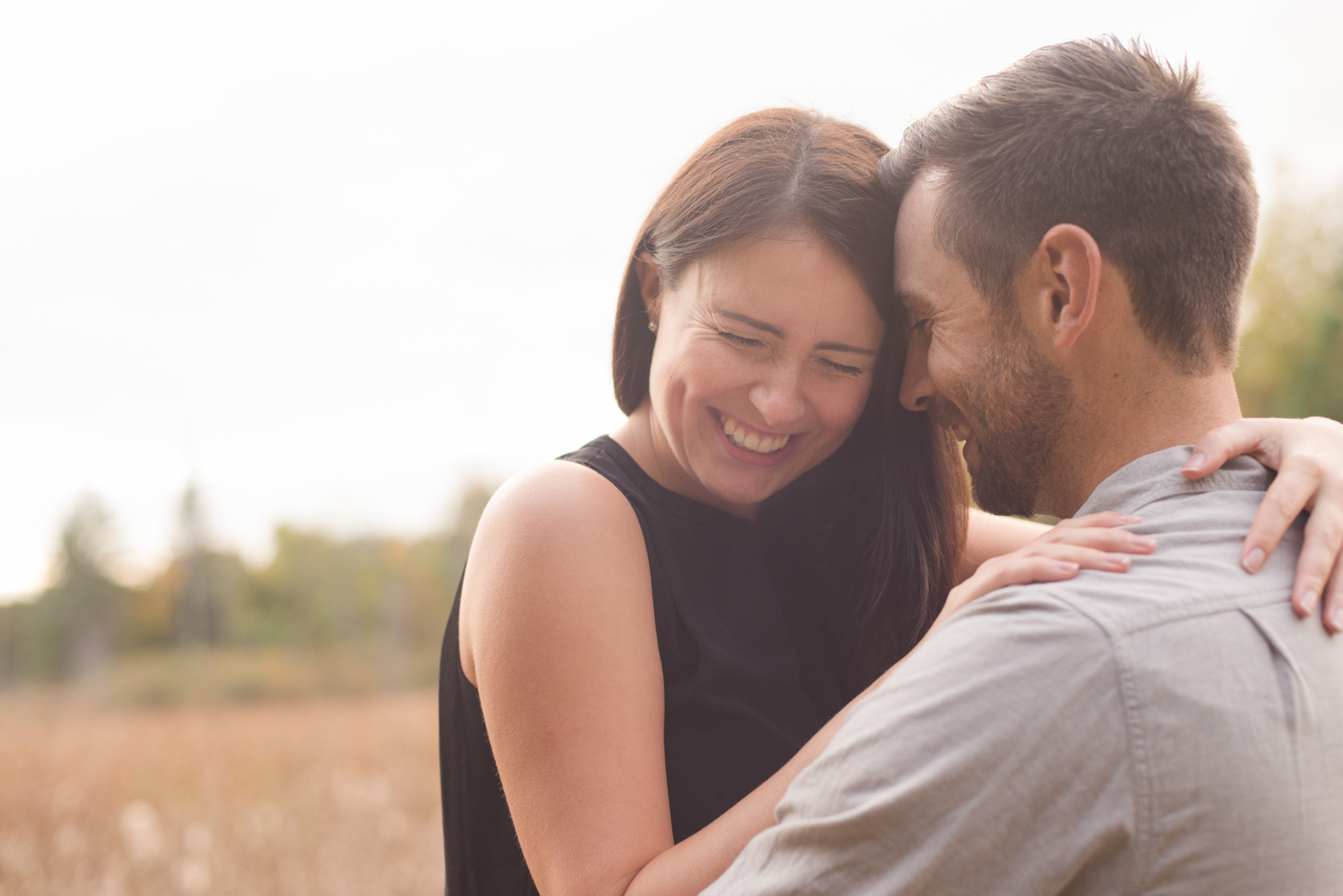 newly engaged couple cuddling in the wilderness