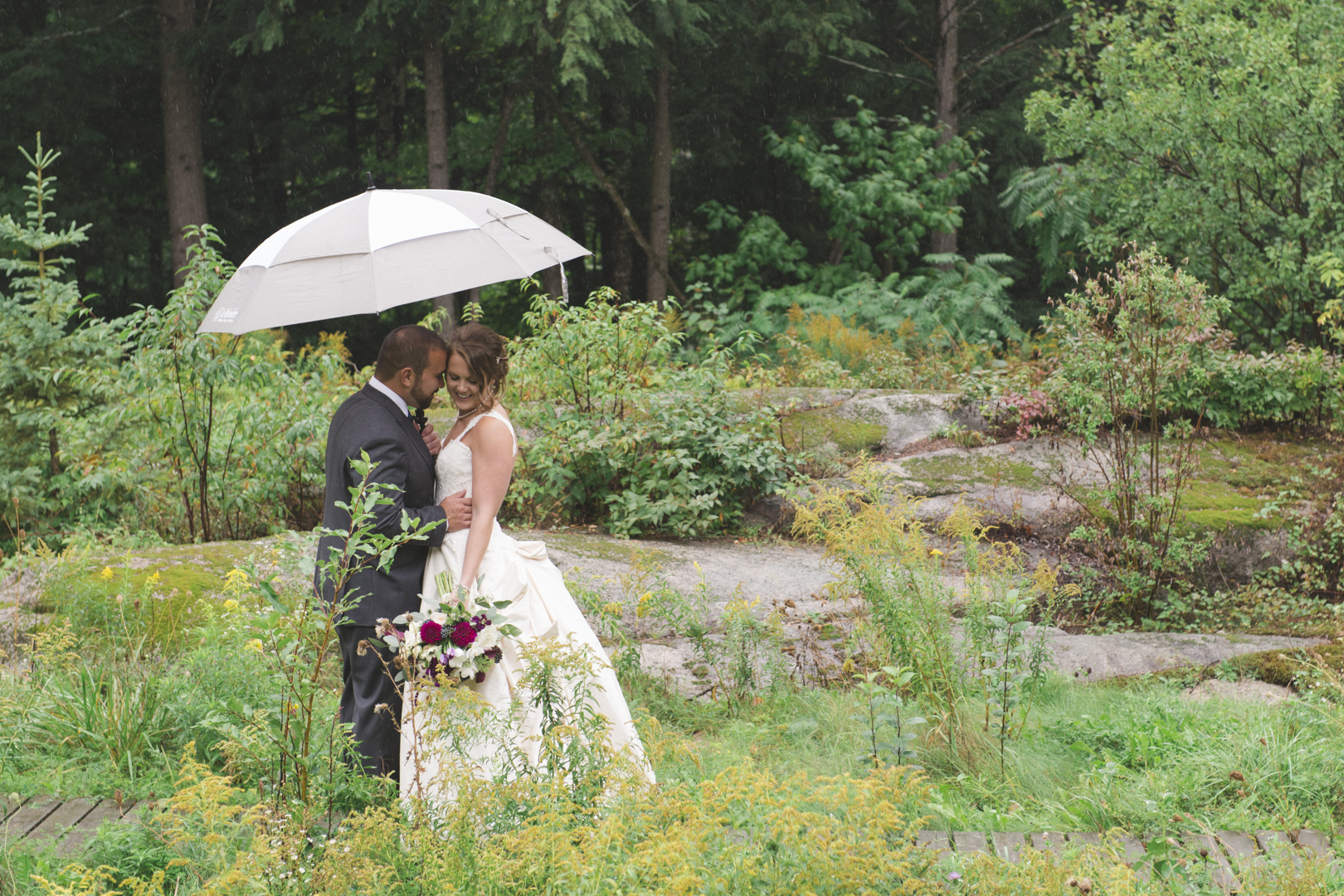 bride and groom standing in the rain at le belvedere guest house