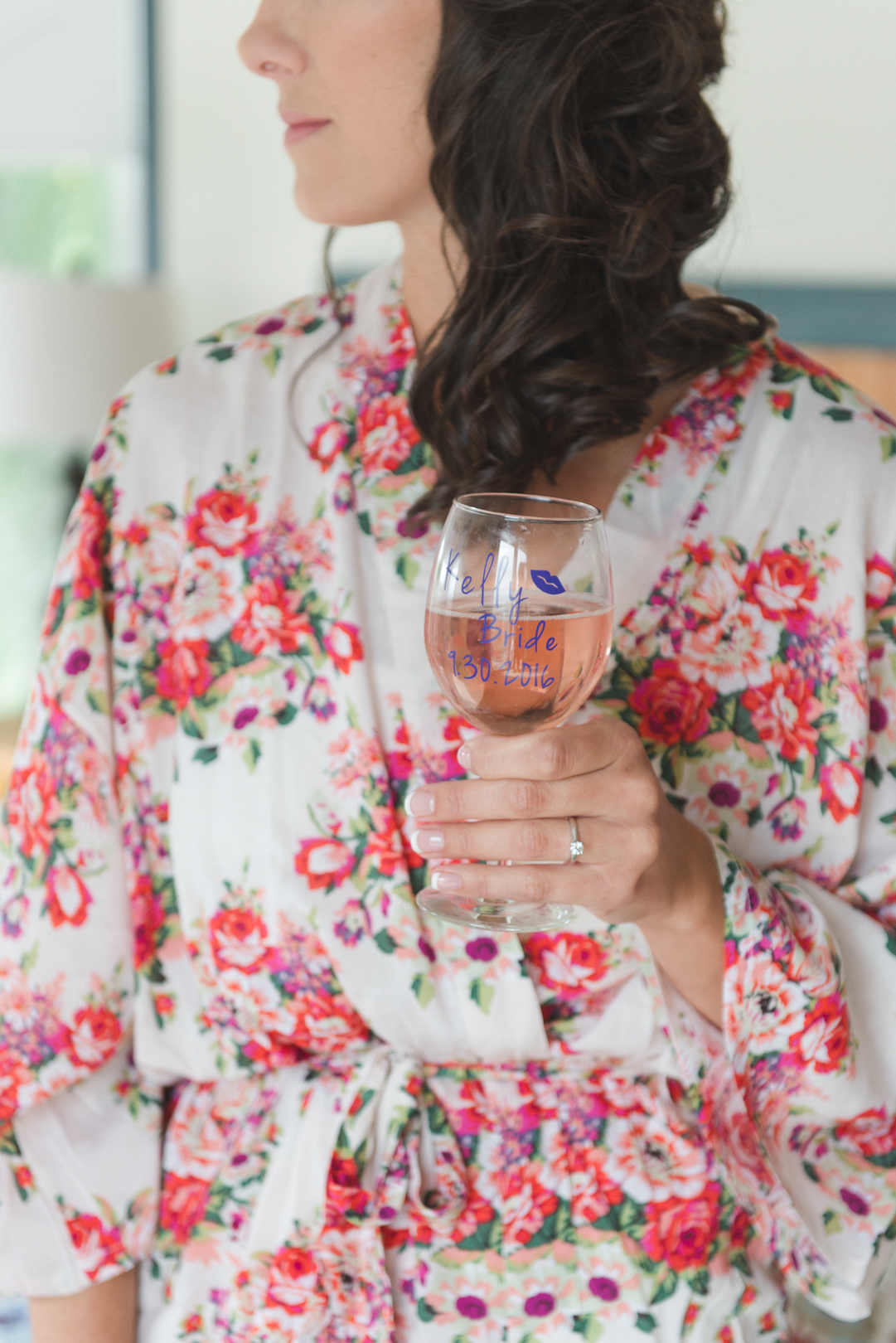 bride wearing floral robe and personalized wine glass