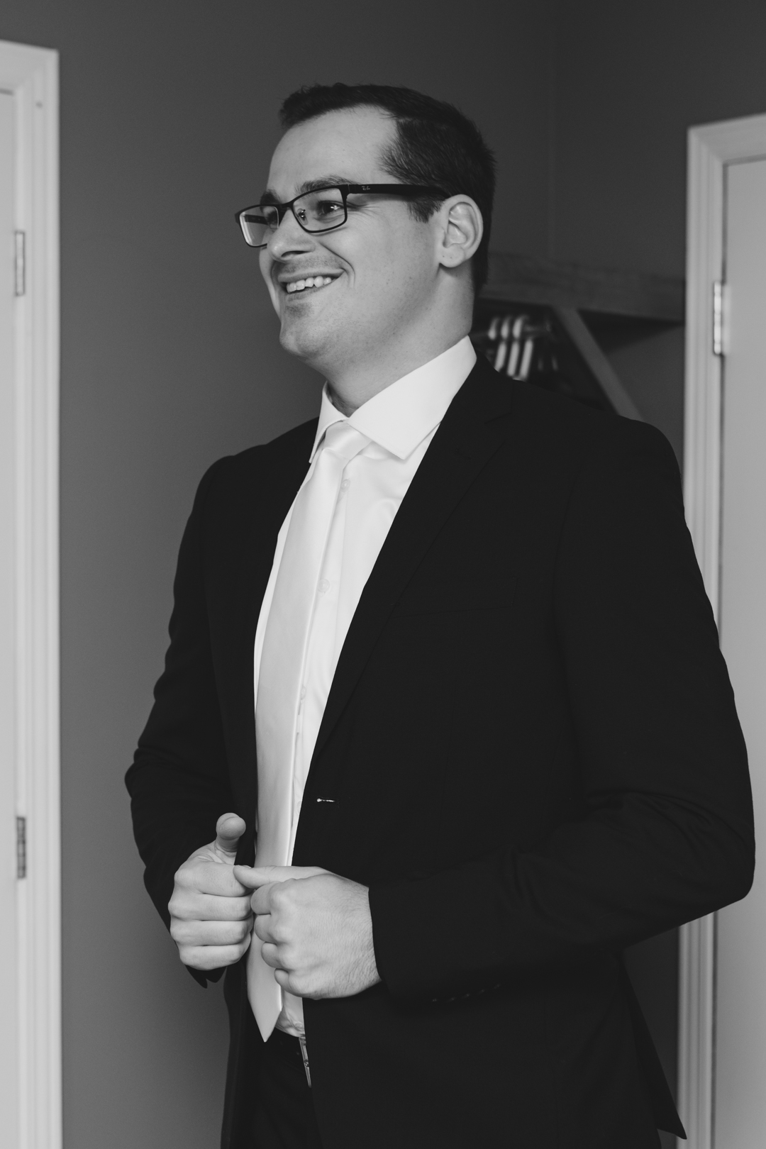 groom putting on suit jacket