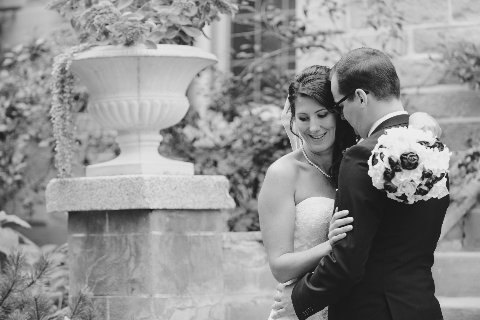 bride and groom cuddling in front of the inn at Strathmere in Ottawa