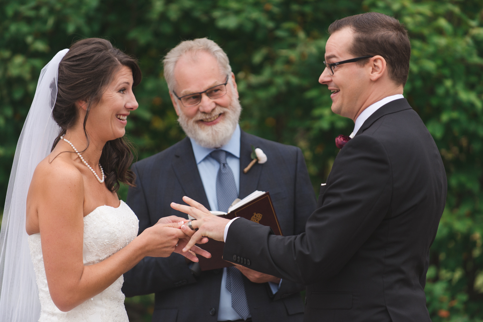 bride and groom exchanging rings at the wedding ceremony at strathmere