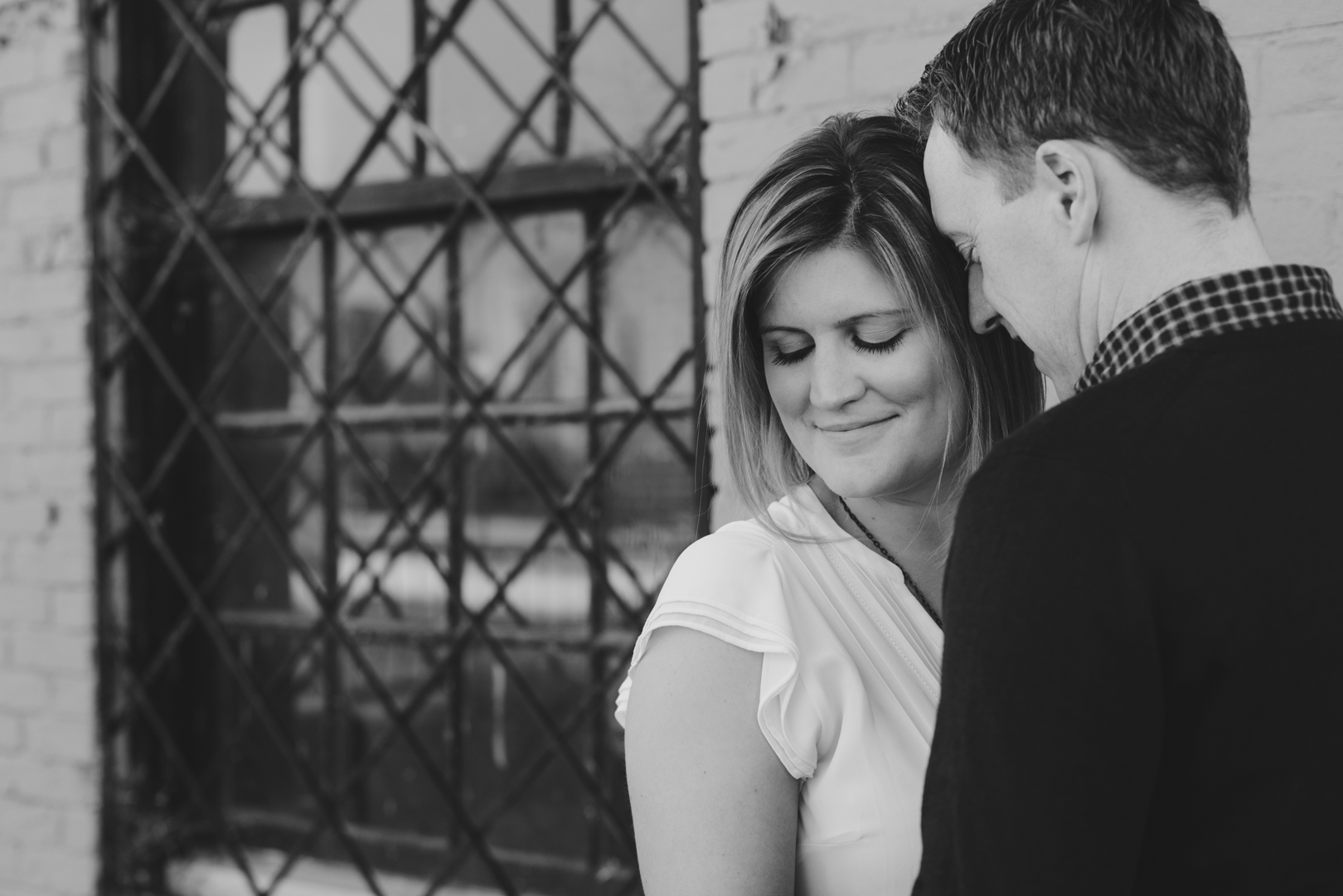 couple cuddling with old bar window behind