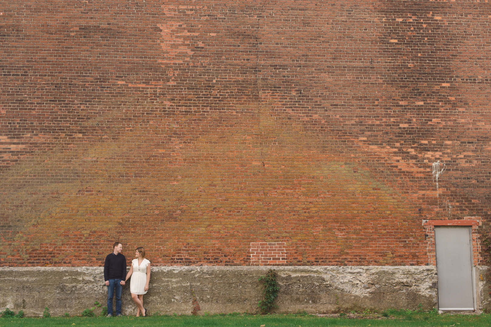 couple standing against a brick wall