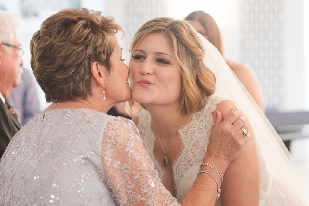 bride kissing her mother at wedding ceremony