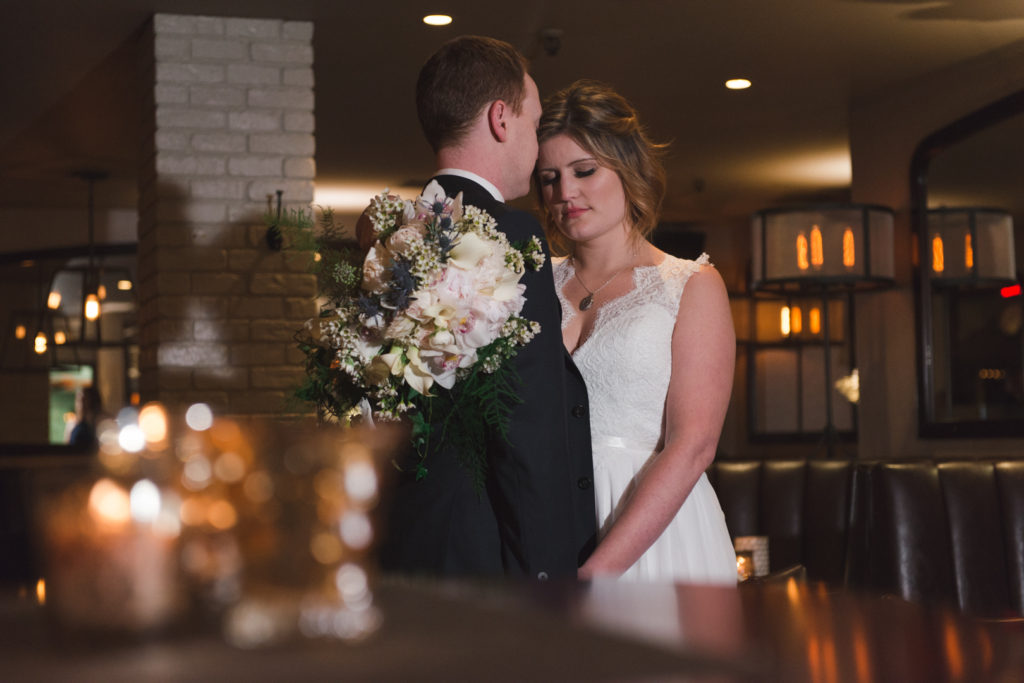 bride and groom cudding in luxe bistro