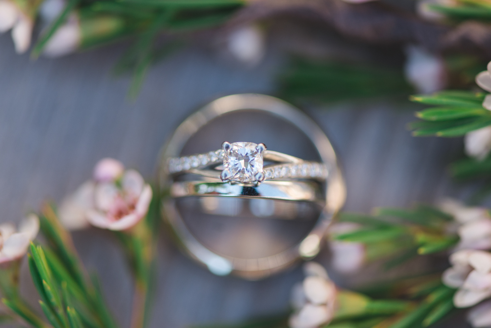 wedding rings among purple flowers and pine