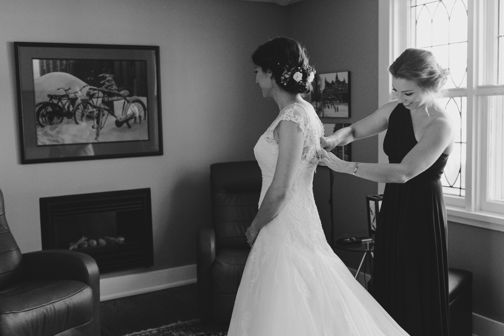 maid of honor tying up bride's dress