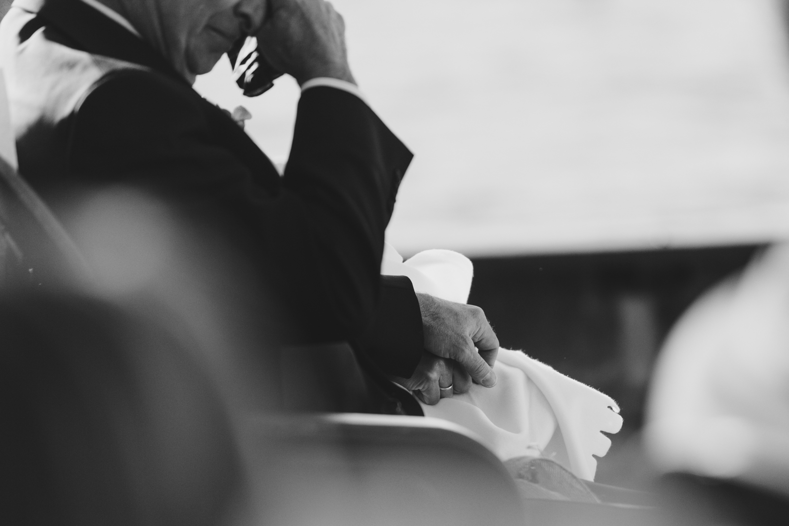 Father of the bride wiping away tears during wedding ceremony