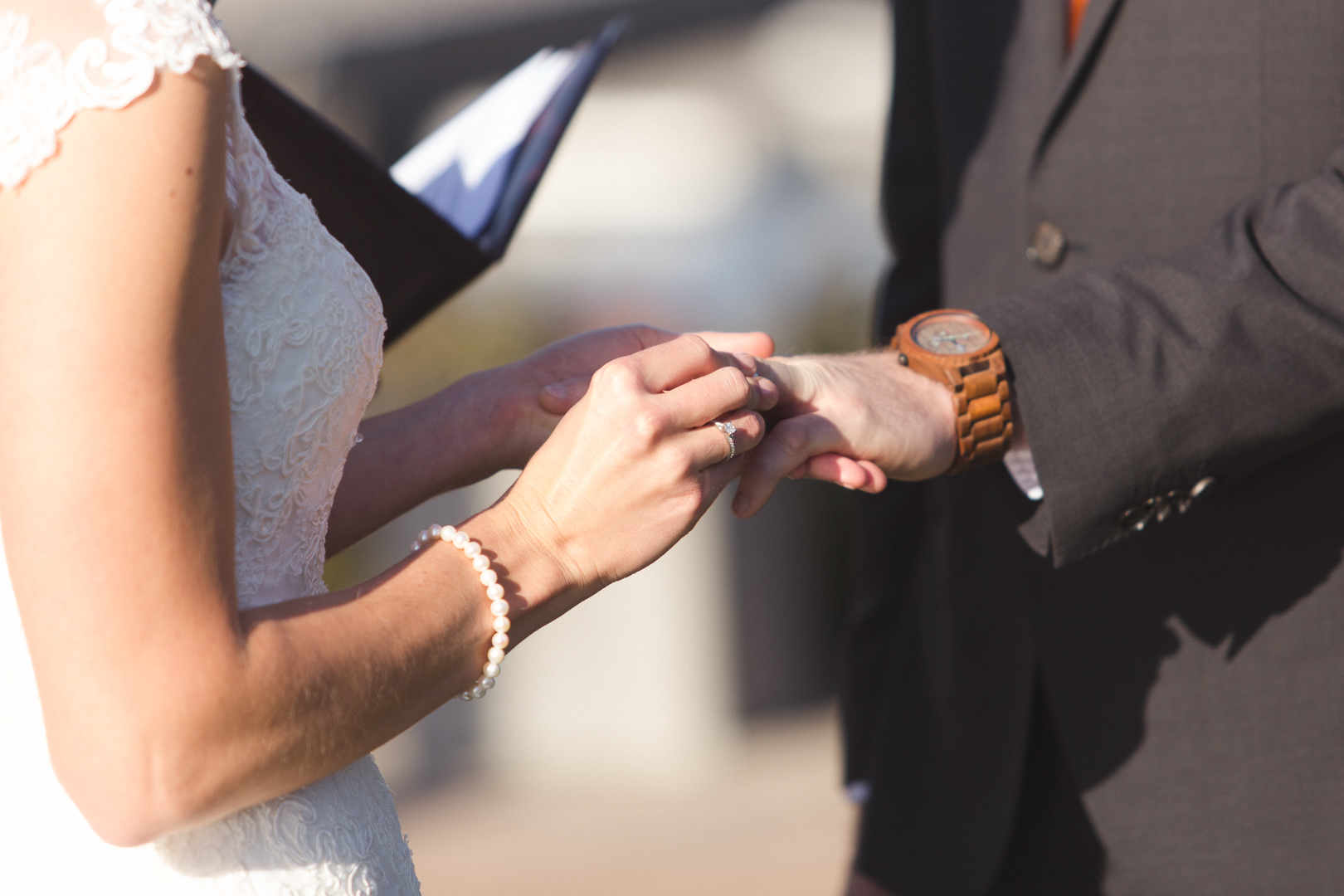 Bride putting on groom's wedding band during ceremony