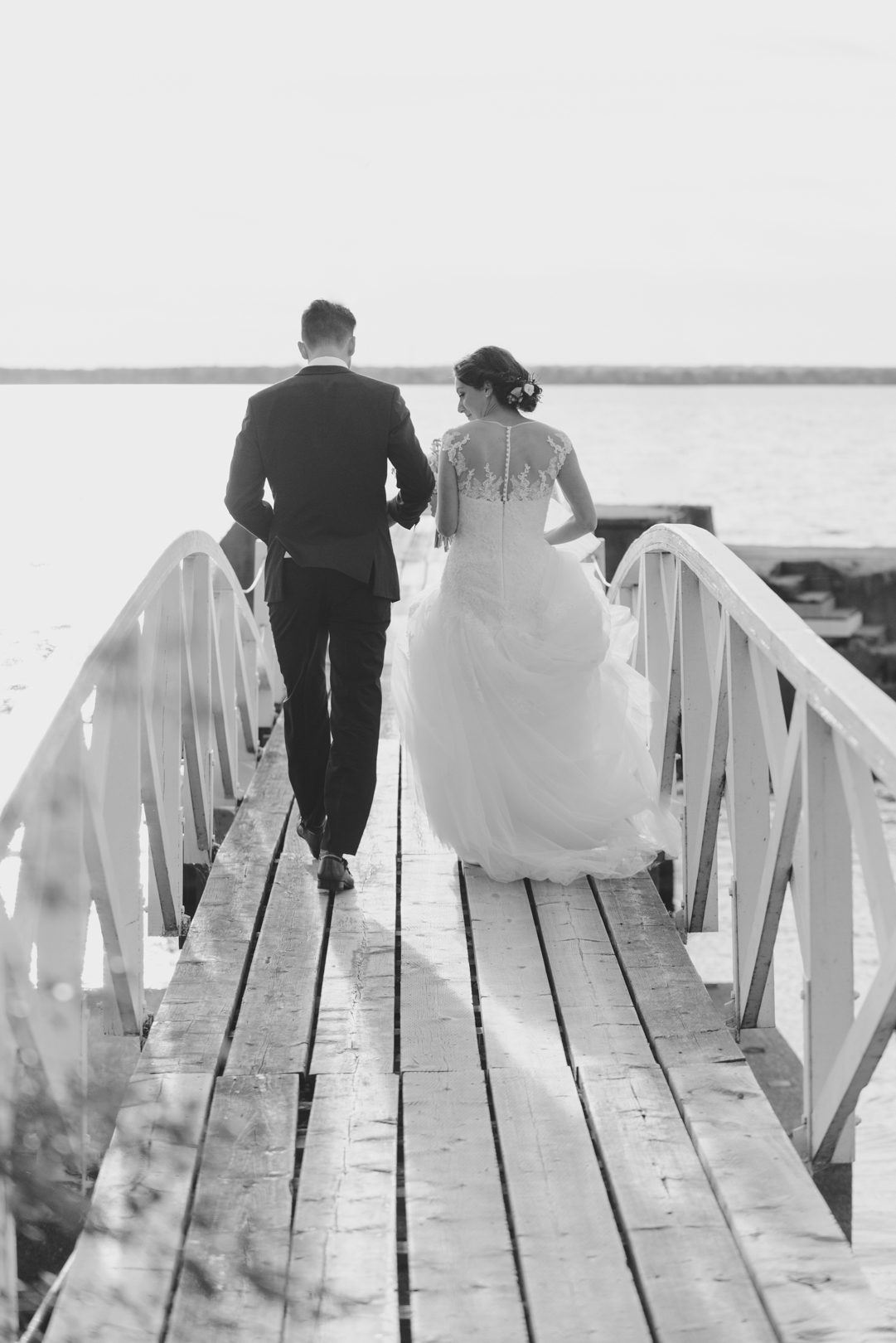 bride and groom walking along little white bridge at Britannia Yacht Club