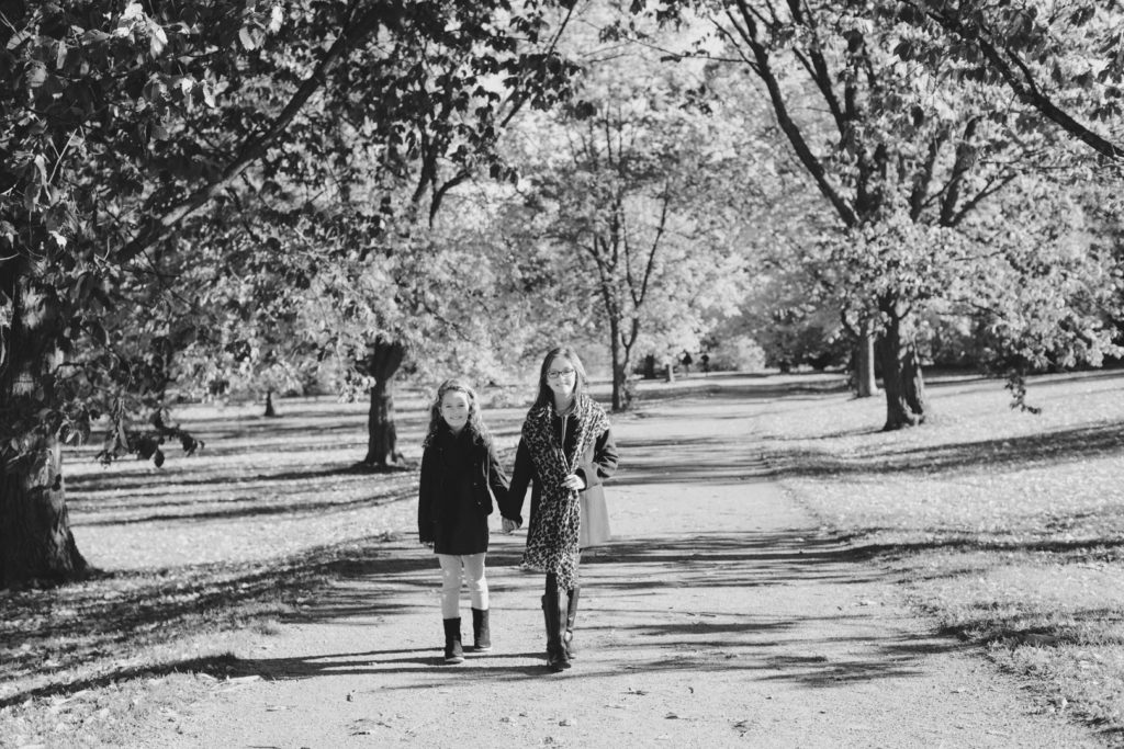 two sisters walking together down a path at the Ottawa arboretum in black and white