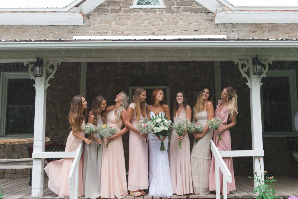 bridesmaids in blush standing on steps of old house at Stanley's maple lane farm